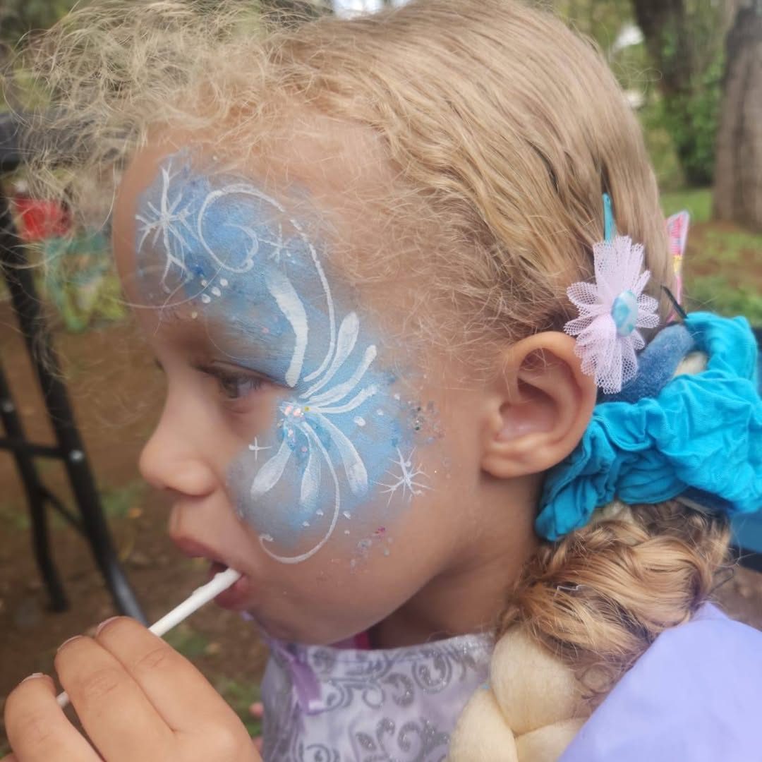 Petite fille maquillée en reine des neiges, flocons bleus et blancs